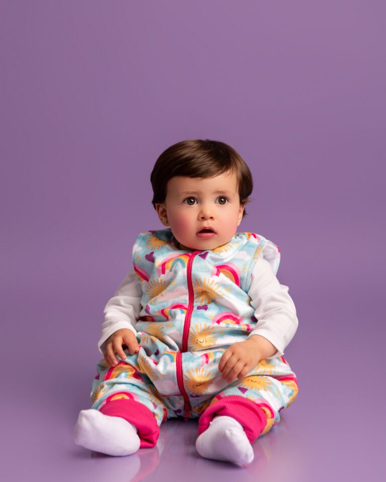 Bebé sentado con el saco de dormir con pies BabyArcoíris de BeBaby Colombia